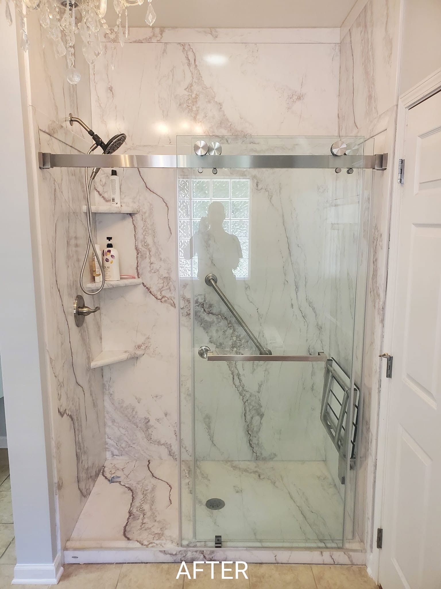 Finished walk-in shower with cultured marble walls and glass door